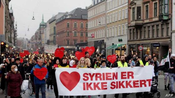 Demonstrators march with a banner reading 'Syria is not safe' during a protest against the deportation of Syrian families to their homeland in Copenhagen on November 13, 2021. - Their lives are paused in a never-ending wait: Bilal Alkale and his family are among the hundreds of Syrian refugees in Denmark whose temporary residency permits have been revoked -- but they can't be deported and now they have no rights. (Photo by Thibault Savary / AFP)