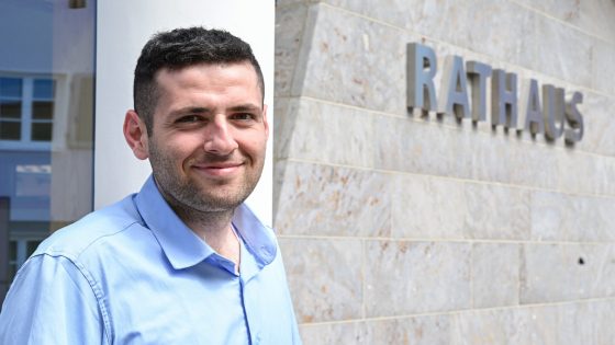 PRODUKTION - 05.07.2023, Baden-Württemberg, Ostelsheim: Ryyan Alsheblsteht vor dem Rathaus in Ostelsheim. Er ist der erste Geflüchtete aus Syrien, der es zum Bürgermeister geschafft hat. Foto: Bernd Weißbrod/dpa +++ dpa-Bildfunk +++